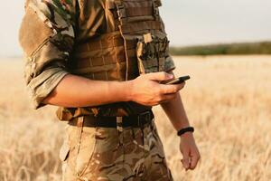 medio sezione di militare soldato utilizzando mobile Telefono foto