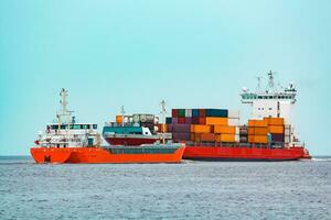 arancia sfuso in movimento passato il rosso contenitore nave nel baltico mare foto