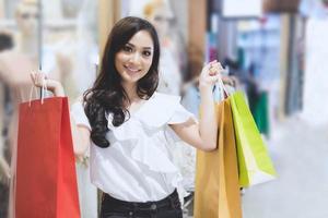 le donne asiatiche e la bella ragazza tengono in mano le borse della spesa sorridendo mentre fanno la spesa al supermercato foto