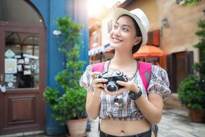 le donne asiatiche indossano una camicia a quadri e zaini che camminano insieme e sono felici di scattare foto e selfie, rilassarsi durante il viaggio di concetto di vacanza
