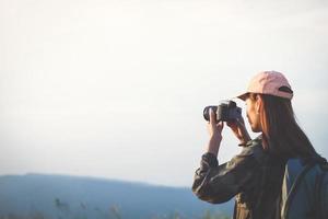 giovani donne asiatiche persone che fanno escursioni con gli amici zaini che camminano insieme e guardano la mappa e prendono la macchina fotografica per strada e sembrano felici, tempo di relax in vacanza concetto di viaggio foto