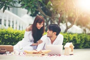 felice coppia romantica amante che parla e beve vino mentre fa un picnic a casa foto