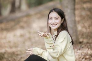 bella donna asiatica sorridente ragazza felice e indossando abiti caldi ritratto invernale e autunnale all'aperto nel parco foto