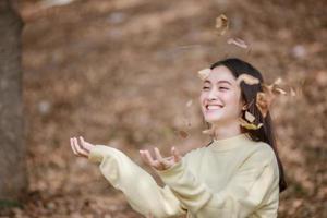 bella donna asiatica sorridente ragazza felice e indossando abiti caldi ritratto invernale e autunnale all'aperto nel parco foto
