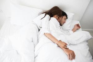 amante delle coppie sdraiato sul letto stile di vita felice e ragazza sorridente che si rilassa nel letto bianco foto