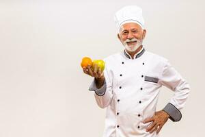 Immagine di anziano capocuoco Tenere frutta e pensiero su grigio sfondo. foto