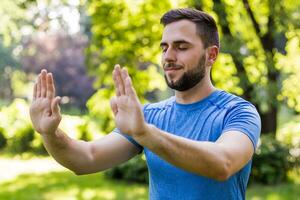 bello uomo esercizio tai chi nel il parco foto