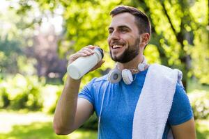 sportivo uomo potabile acqua nel il parco. foto