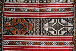 un vecchio tappeto con un' rosso, bianca e nero design foto