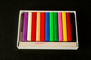 un' scatola di colorato pastelli nel un' bianca scatola foto