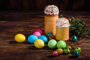 torta di pasqua e uova colorate su sfondo scuro foto