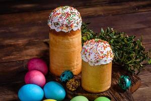 torta di pasqua e uova colorate su sfondo scuro foto