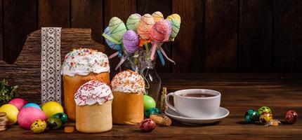 torta di pasqua e uova colorate su sfondo scuro foto