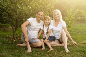 ritratto di allegro esteso famiglia seduta nel il parco foto