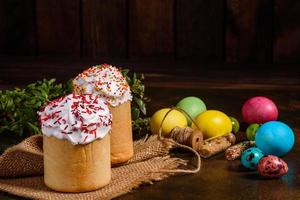 torta di pasqua e uova colorate su sfondo scuro foto