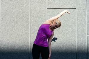sport donna fare allungamento esercizio durante all'aperto attraversare formazione allenarsi foto