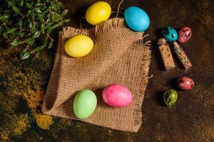torta di pasqua e uova colorate su sfondo scuro foto