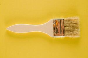 un' dipingere spazzola con un' giallo sfondo foto