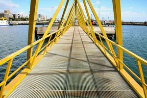 un' giallo ponte al di sopra di il acqua con un' città nel il sfondo foto