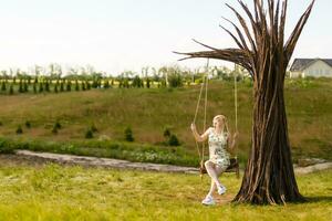 un' giovane donna è oscillante su un' swing nel un' parco ambientazione. foto