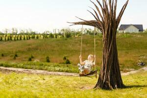 un' giovane donna è oscillante su un' swing nel un' parco ambientazione. foto