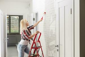 bellissimo giovane donna pittura parete nel camera foto