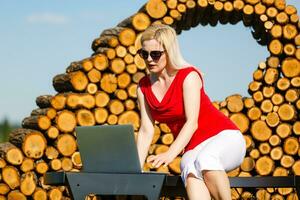 giovane bella donna con il computer portatile su il panchina nel un' parco foto