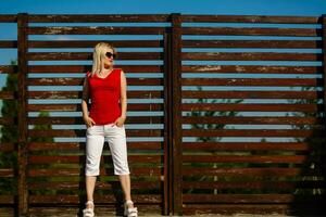 attraente giovane donna godendo sua tempo al di fuori nel parco con tramonto nel sfondo. foto