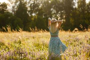 salutare bellissimo donna a piedi all'aperto. allettante giovane donna nel Grano campo, delicato sensuale donna su natura. Perfetto pelle, Riccio capelli. foto