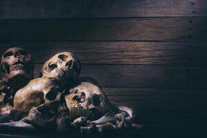 fotografia di natura morta con teschi umani su sfondo di tavolo in legno vecchio - halloween o concetto esoterico