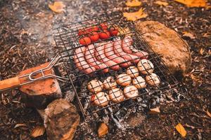 cucinare il cibo sul falò. concetto di campeggio foto