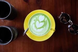 vista dall'alto della schiuma di latte art con tè verde matcha caldo foto