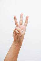 mano dell'uomo che mostra tre dita su sfondo bianco foto