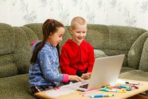 distanza apprendimento in linea formazione scolastica. scuola ragazzo e ragazza studiando a casa con il computer portatile taccuino e fare compiti a casa. seduta a un' tavolo foto