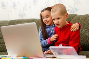 distanza apprendimento in linea formazione scolastica. scuola ragazzo e ragazza studiando a casa con il computer portatile taccuino e fare compiti a casa. seduta a un' tavolo foto