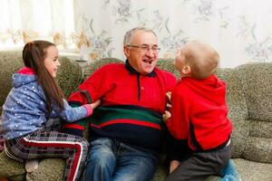 nonno spende tempo con nipoti nel il vivente camera foto