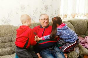 nonno spende tempo con nipoti nel il vivente camera foto