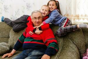 nonno spende tempo con nipoti nel il vivente camera foto