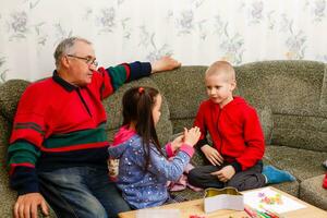 nonno spende tempo con nipoti nel il vivente camera foto