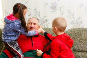 nonno spende tempo con nipoti nel il vivente camera foto