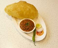 indiano cucina buco bhature anche conoscere come pulcino pisello curry, buco bhture o cola, chana masala servito con fritte puri è un' piatto a partire dal il Punjab foto
