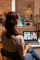 donna parlando con collaboratori durante video conferenza a mezzanotte a partire dal casa Tenere un' tazza di caffè. aziendale incontro utilizzando moderno tecnologia, il computer portatile in ritardo a notte , tecnologia, agenzia, consulente, opera, discussione. foto