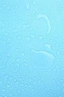 gocce d'acqua su sfondo blu con uno spazio vuoto per un testo foto