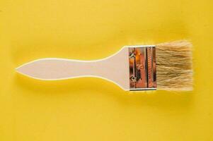 un' dipingere spazzola su un' giallo sfondo foto