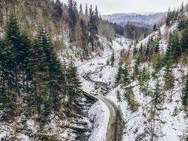 veduta aerea dell'auto in movimento dal canyon durante l'inverno nevoso foto