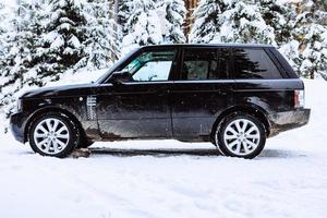 auto suv nella foresta innevata foto