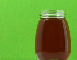 un' vaso di miele seduta su un' verde sfondo foto
