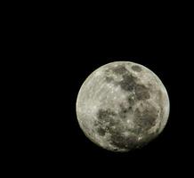 il pieno Luna è visto nel il buio cielo foto