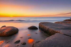 ai generato bellissimo rocce su il spiaggia a tramonto. professionista foto