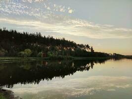 lago e foresta nel tramonto, pittoresco sfondo foto